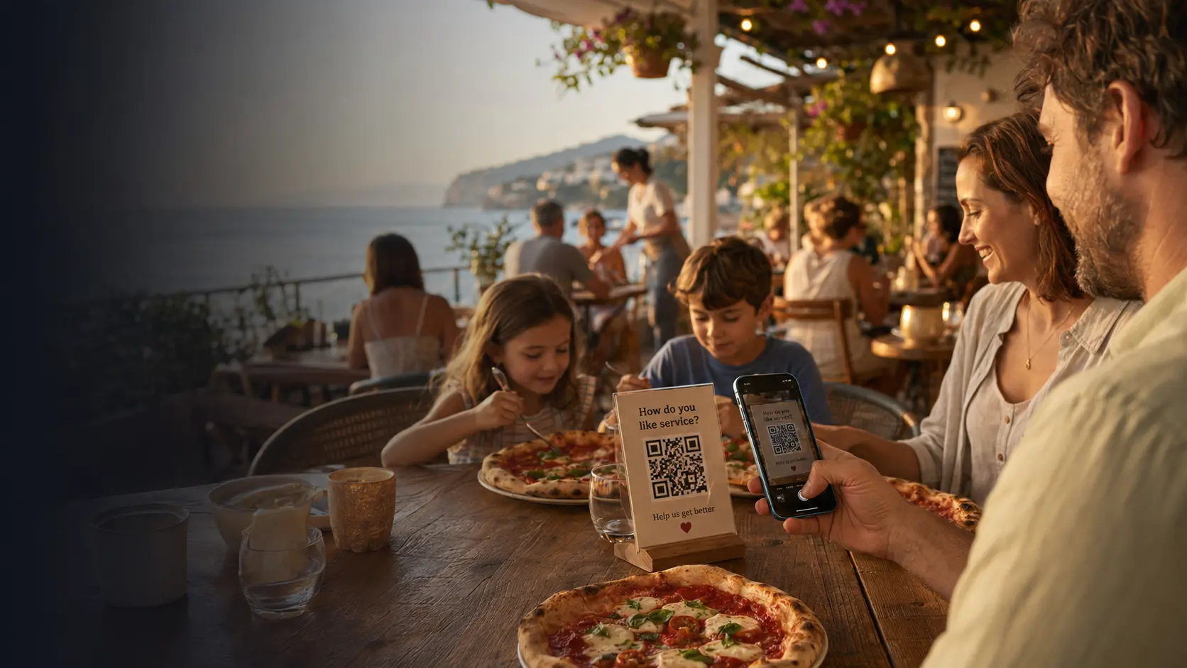 Family at a seaside restaurant while a guest scans a private feedback QR code